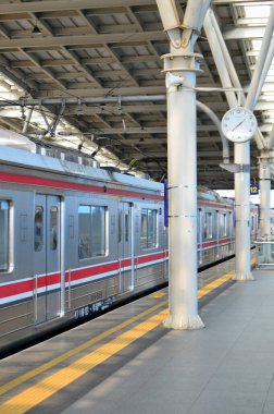 Tren yolcu beklemeyi bırakır ve duvar saati de günün saatini gösterir.