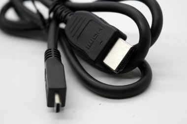 Beyaz arka planda düzgünce sarılmış siyah monitör kablosu