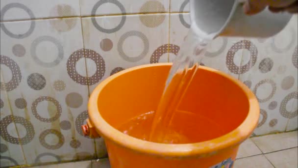 Wytryskająca Woda Kranu Napełniająca Pomarańczowe Wiadro Łazience — Wideo stockowe