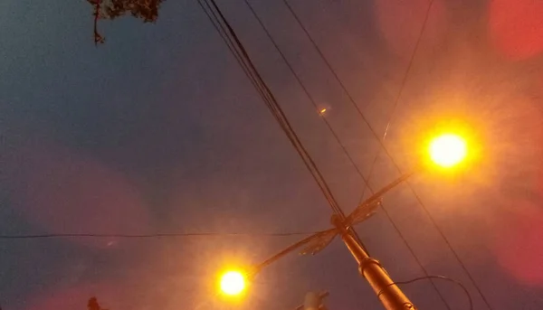 夜の明るい黄色の街路灯と電柱 — ストック写真