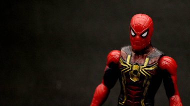 Örümcek Adam oyuncağı siyah arkaplanda poz verir