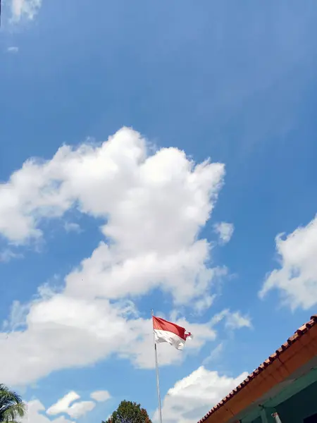 インドネシアの国旗が美しい空と雲に浮かぶ — ストック写真