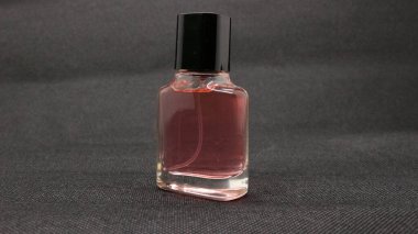 Siyah arkaplanda izole edilmiş pembe parfüm.