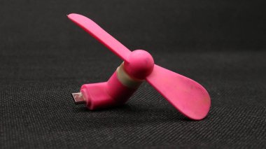 Taşınabilir USB pembe fan siyah arkaplanda izole edildi