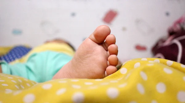 把小宝宝的脚贴在床垫上 — 图库照片