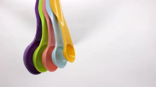Measuring spoons in various colors. measuring spoons in many sizes and many colors.