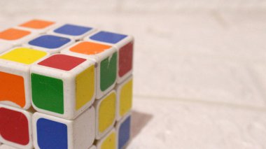 Krema arkaplanlı Rubik küpünün yakın görüntüsü.