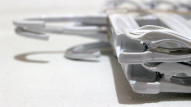 Beyaz arka planda bir yığın beyaz elbise asılı.