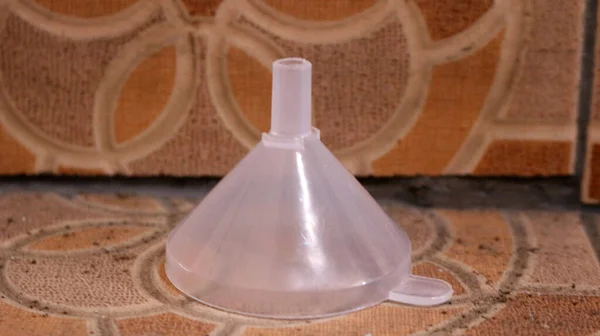 Plastic funnel isolated on brown ceramic