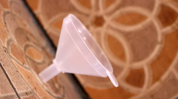 Plastic funnel isolated on brown ceramic