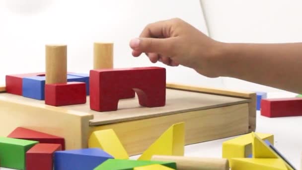 Ένα Παιδί Παίζει Πολύχρωμα Ξύλινα Παιχνίδια Παζλ Που Συναρμολογούνται Λευκό — Αρχείο Βίντεο