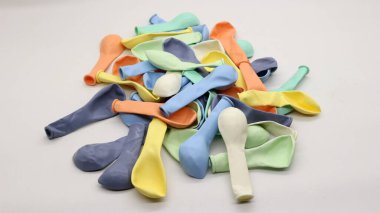 Beyaz arka planda şişirilmemiş renkli balonlar.