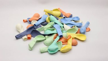 Beyaz arka planda şişirilmemiş renkli balonlar.