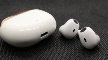 Beyaz baz rengi ve altın kaplamalı kablosuz kulaklık beyaz arka planda çok zarif görünüyor..