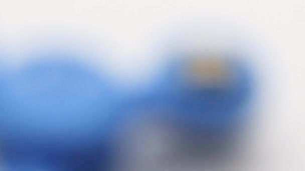 一个男人在白色的背景上扮演一个蓝色的纺纱机 看上去很开心 — 图库视频影像