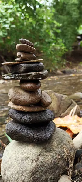 Close up of stacks of rocks on the river bank in a forest