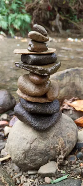 Close up of stacks of rocks on the river bank in a forest