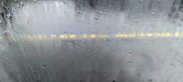 View of the highway from the foggy glass during the rain