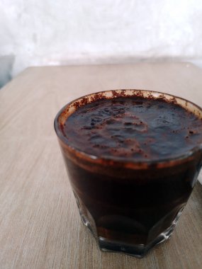 Koyu kahve ve kaşıkla bardaktaki manzarayı kapat