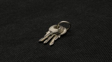 Anahtar, siyah arkaplanlı gümüş. Bu anahtar küçük olduğu için eşsizdir..