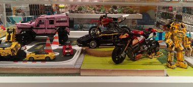 Mağazada satılık oyuncak arabalar ve robot motosikletler sergileniyor