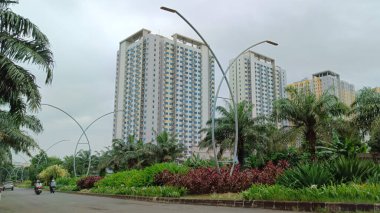 Apartman manzarası aşağıdan ağaçlar ve parlak bulutlarla kaplı