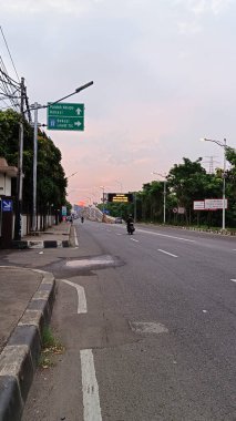 Bekasi şehrindeki otoyolun atmosferi motosiklet ve arabalarla dolu.