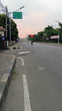 Bekasi şehrindeki otoyolun atmosferi motosiklet ve arabalarla dolu.
