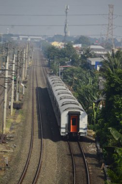 Kırsal kesimde seyahat eden bir yolcu treni görüntüsü. İki tren yolu görebilirsiniz ve bu gerçekten çok güzel bir manzara..