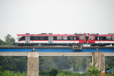 Demiryolu köprüsünden geçen bir yolcu treni görüntüsü. Ne güzel bir manzara..