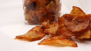 Beyaz arkaplanda izole edilmiş kavanozdaki baharatlı cipsler