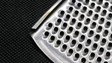 Siyah arkaplanda küçük metal peynir rendesi izole edilmiş