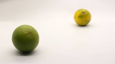 Beyaz arka planlı, yeşil, sarı ve turuncu tenli, Endonezya 'dan portakal meyvesi..