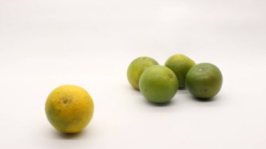 Beyaz arka planlı, yeşil, sarı ve turuncu tenli, Endonezya 'dan portakal meyvesi..