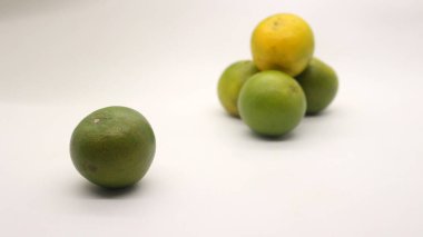 Beyaz arka planlı, yeşil, sarı ve turuncu tenli, Endonezya 'dan portakal meyvesi..