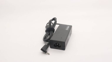 Beyaz arkaplanda güç kablosu ve defter adaptörü.