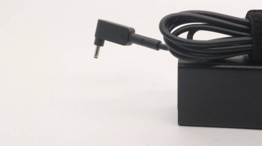 Beyaz arkaplanda güç kablosu ve defter adaptörü.