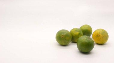 Beyaz arka planlı, yeşil, sarı ve turuncu tenli, Endonezya 'dan portakal meyvesi..