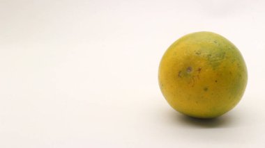 Beyaz arka planlı, yeşil, sarı ve turuncu tenli, Endonezya 'dan portakal meyvesi..