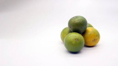 Beyaz arka planlı, yeşil, sarı ve turuncu tenli, Endonezya 'dan portakal meyvesi..