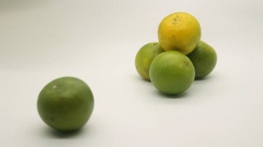 Beyaz arka planlı, yeşil, sarı ve turuncu tenli, Endonezya 'dan portakal meyvesi..