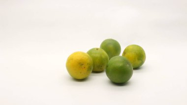 Beyaz arka planlı, yeşil, sarı ve turuncu tenli, Endonezya 'dan portakal meyvesi..