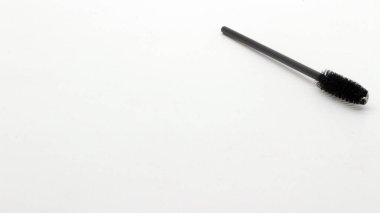 Beyaz arkaplanda siyah kirpik tarağı.