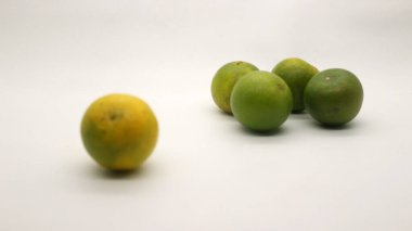 Beyaz arka planlı, yeşil, sarı ve turuncu tenli, Endonezya 'dan portakal meyvesi..