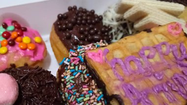 Çeşitli malzemelerle donutlu kek, rengarenk renkleriyle çok lezzetli görünüyor..