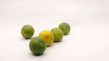 Beyaz arka planlı, yeşil, sarı ve turuncu tenli, Endonezya 'dan portakal meyvesi..