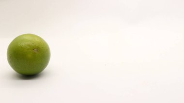 Beyaz arka planlı, yeşil, sarı ve turuncu tenli, Endonezya 'dan portakal meyvesi..