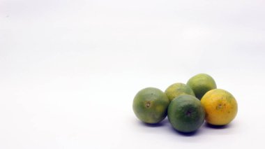 Beyaz arka planlı, yeşil, sarı ve turuncu tenli, Endonezya 'dan portakal meyvesi..