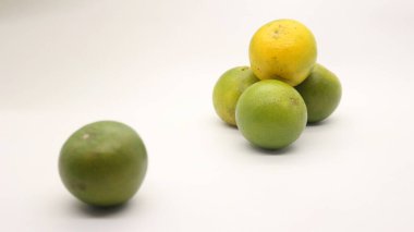 Beyaz arka planlı, yeşil, sarı ve turuncu tenli, Endonezya 'dan portakal meyvesi..