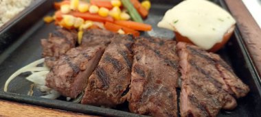 Restoran masasında servis edilen biftek, pirinç ve sebzeleri yakından izleyin.